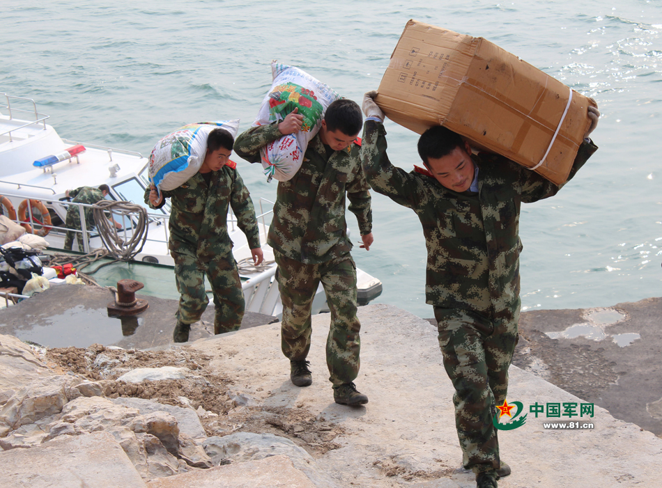 官兵向车牛山岛上扛运育苗基质,肥料和菜苗.费伯俊 摄