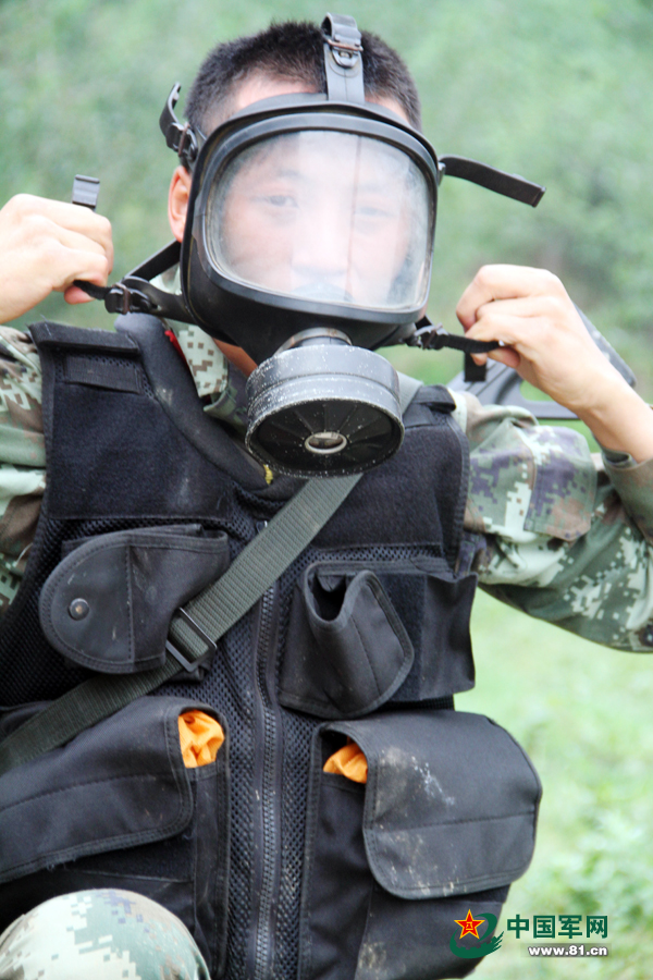 7月2日,武警凉山支队特战队员在比武竞赛中穿戴防毒面具 李结义摄