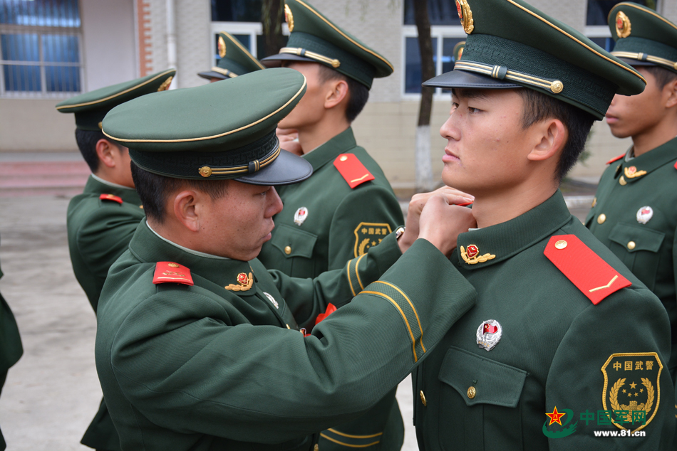 11月25日,武警滁州市支队即将退伍的老兵正在为新战士佩戴警衔.