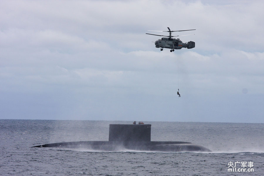潜艇浮出水面后，救援直升机紧急转移部分艇员。琚振华摄