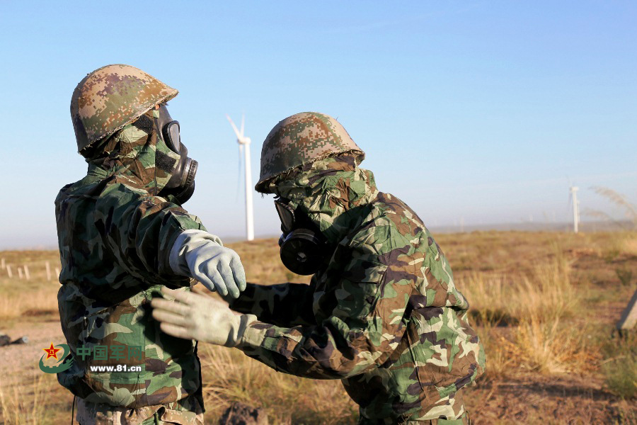 途中遭遇"敌"化学武器袭击,官兵迅速穿戴防化装备,图为官兵正在检查