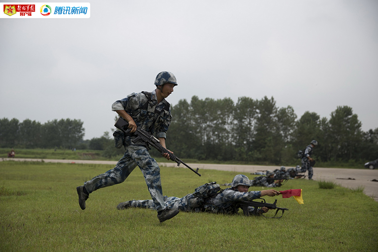 团里安排黄继光班进行班组战术动作示范,班长郑瑞宇正用小旗指挥机枪