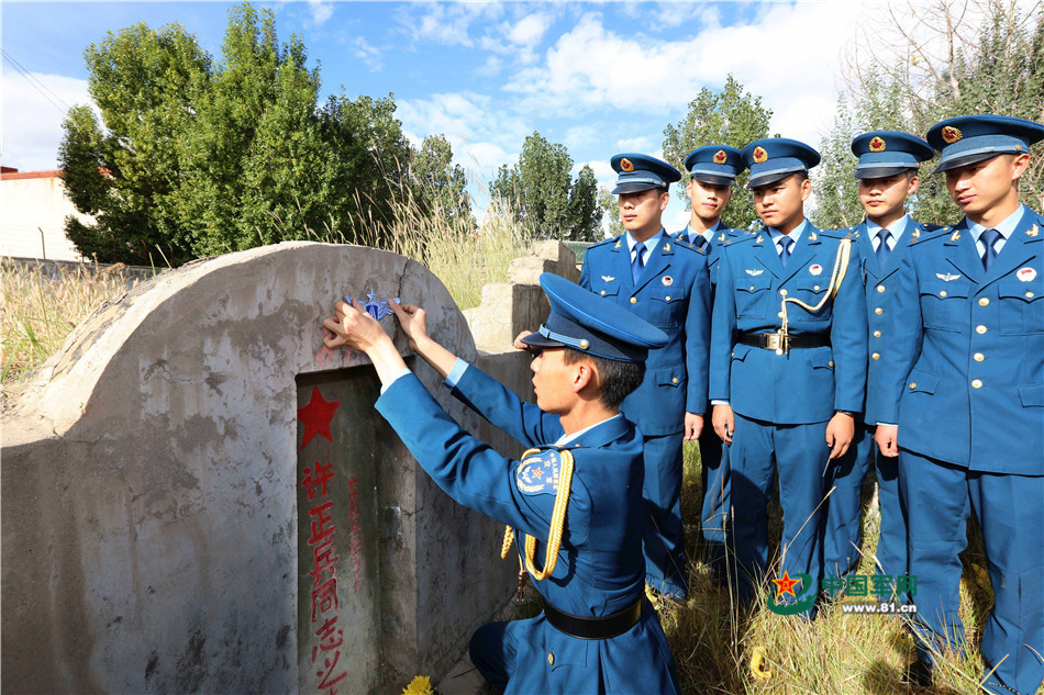 生士兵韩杰来到许正兵烈士墓前,在这位英雄老乡的墓碑上贴上空军徽标